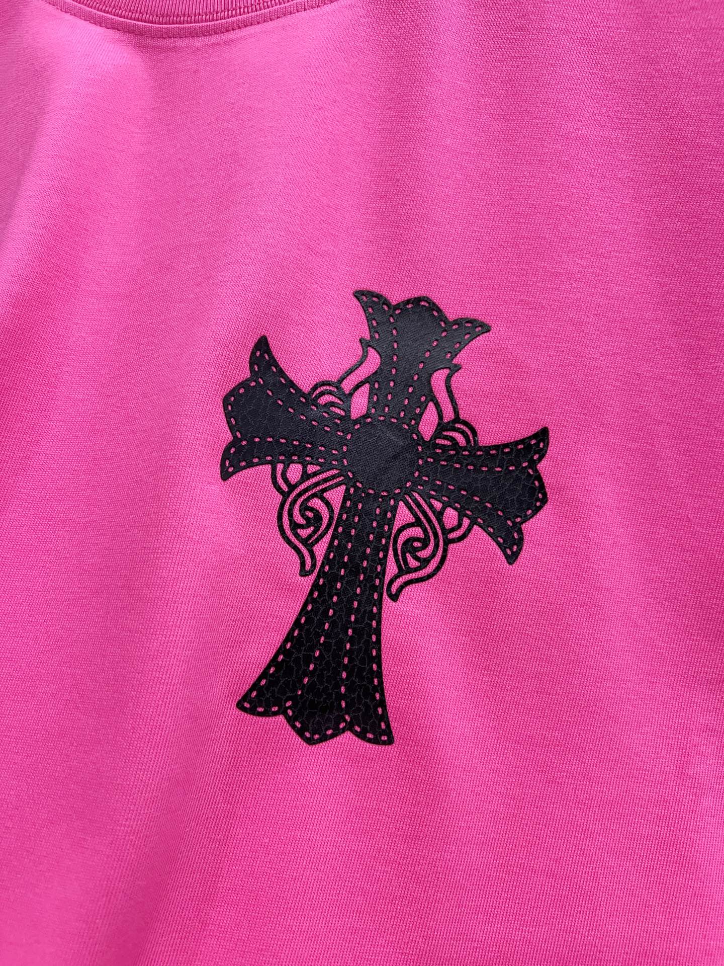 Pink short-sleeve T-shirt with large black cross graphic centered