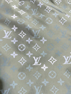 Louis Vuitton monogram fabric close-up, olive green with white repeating motifs