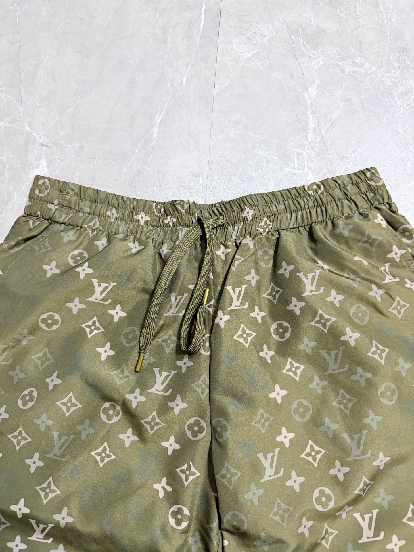 Louis Vuitton monogram shorts close-up, elastic waistband and drawstring, olive green