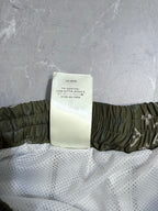 Louis Vuitton shorts product tag on white mesh lining with olive elastic waistband
