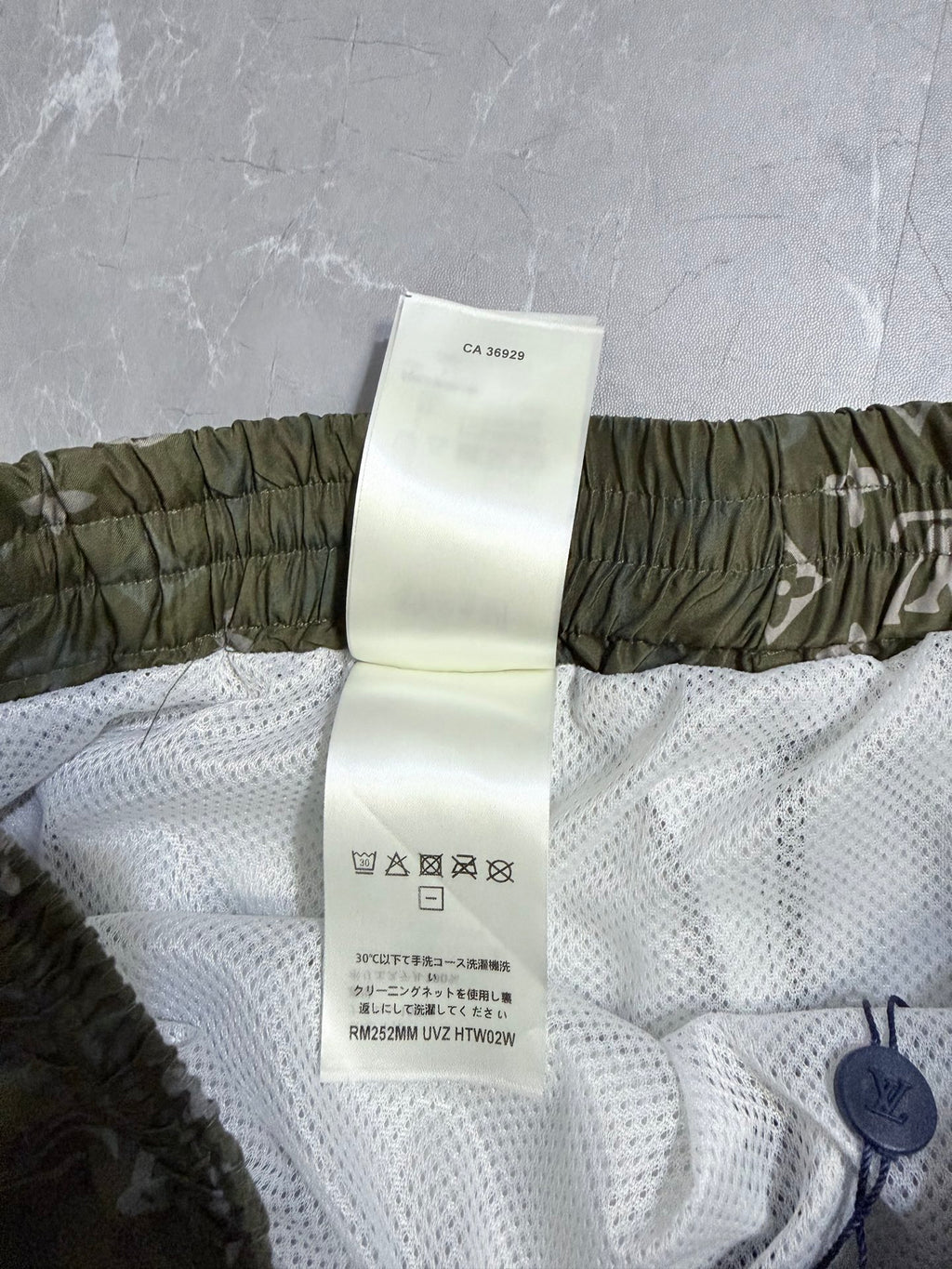 Louis Vuitton shorts care label on white mesh lining with olive elastic waistband