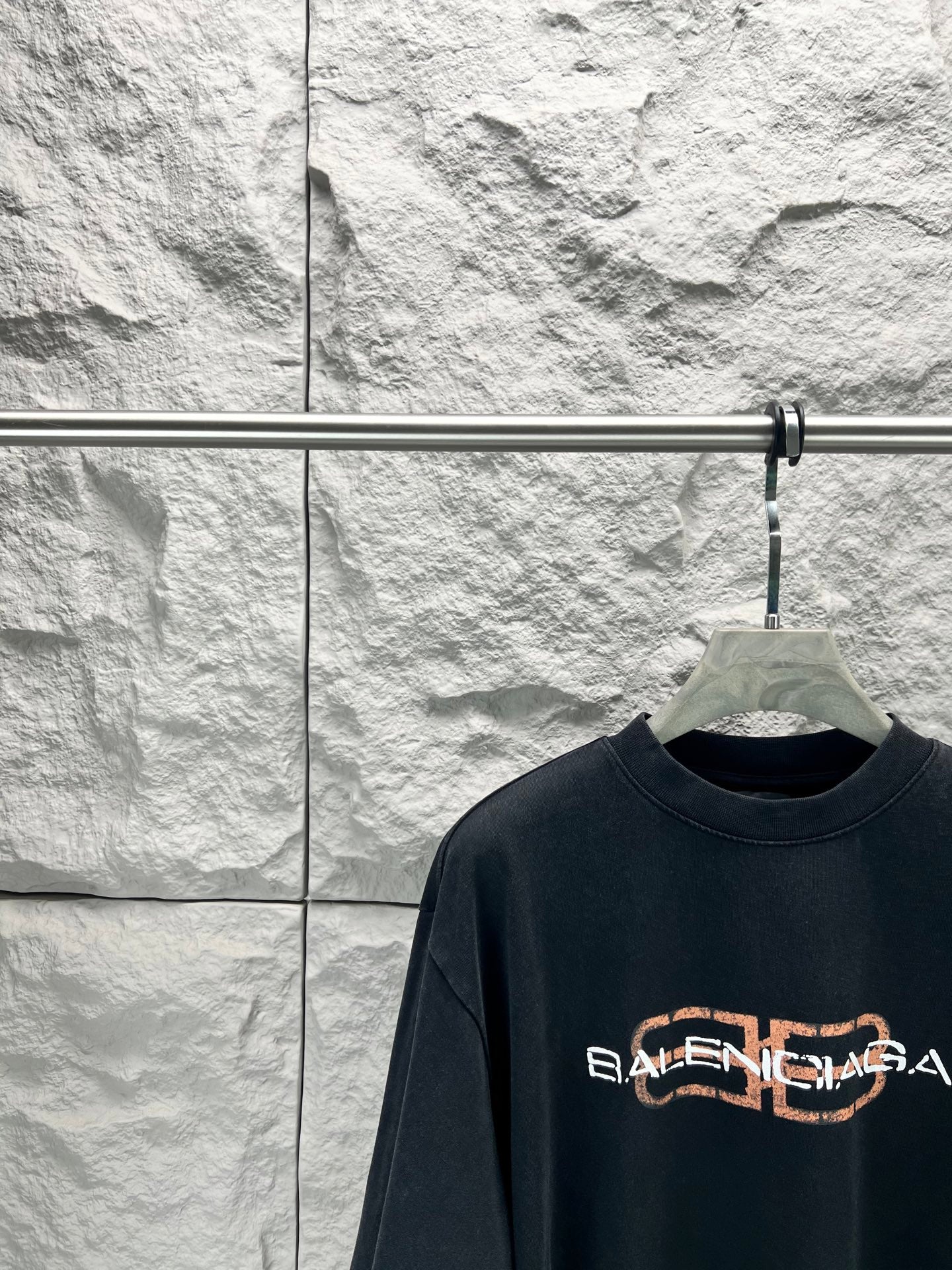 Dark navy Balenciaga short-sleeve T-shirt with orange logo, chest close-up