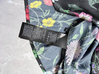 Floral long-sleeve shirt fabric close-up with black size/label tags
