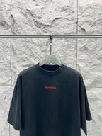 Black short-sleeve shirt with small red Balenciaga logo at center chest