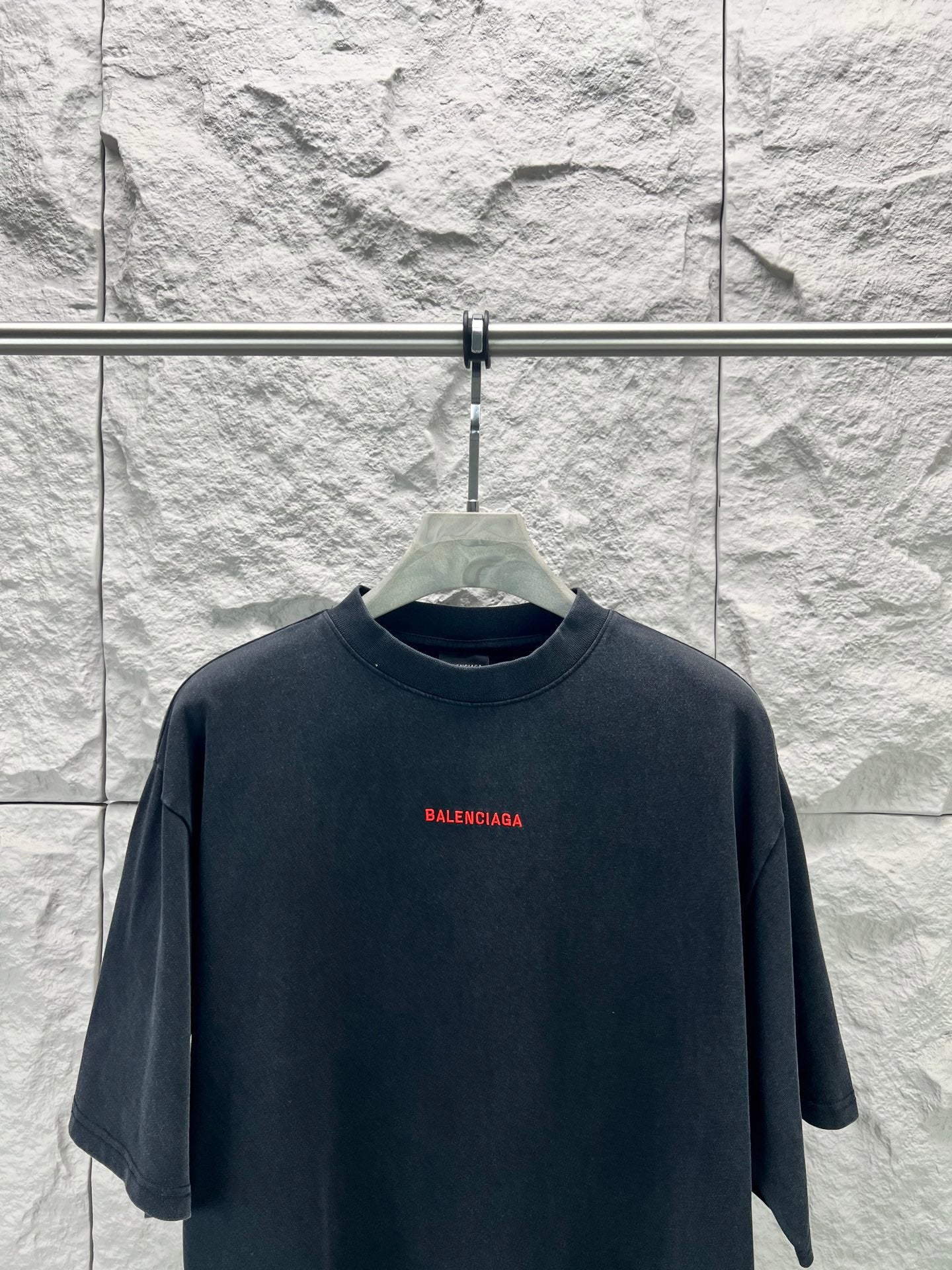 Black short-sleeve shirt with small red Balenciaga logo at center chest