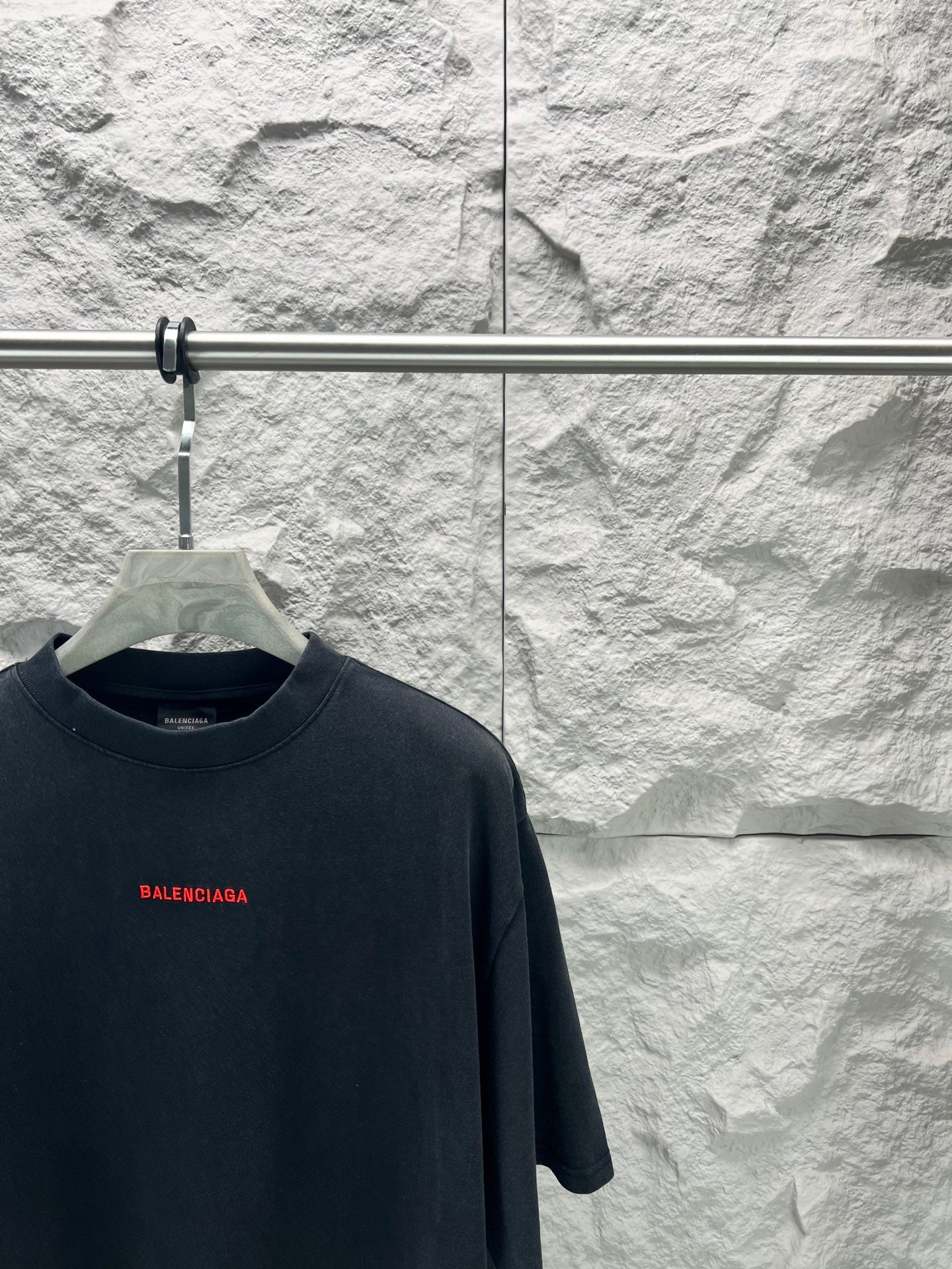Black short-sleeve shirt neckline with small red Balenciaga logo on chest