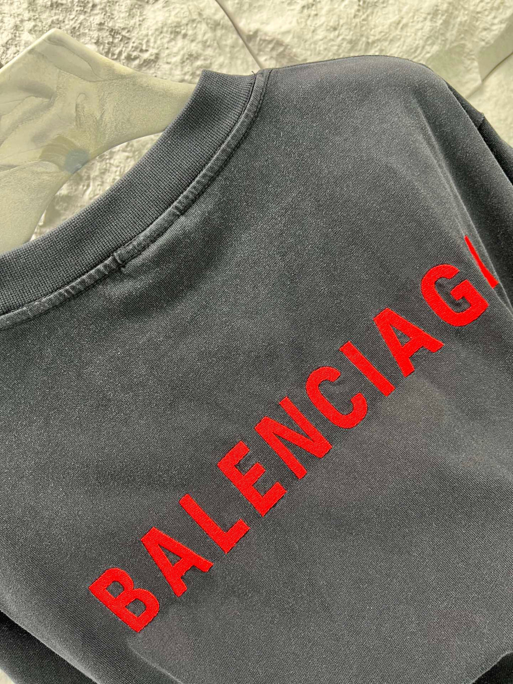 Black short-sleeve shirt close-up with red Balenciaga text print