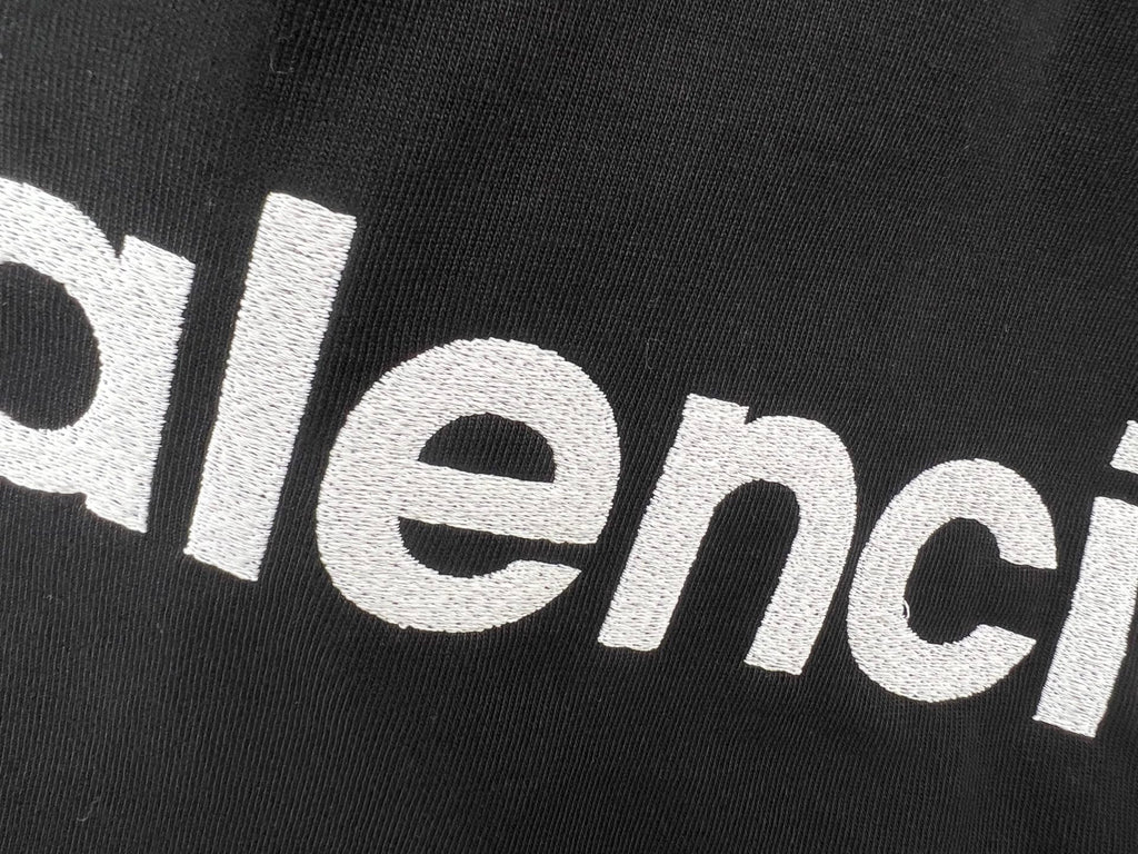 Balenciaga text logo on black T-shirt fabric close-up