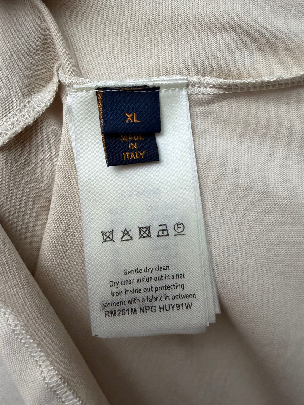 Louis Vuitton T-shirt size XL care label with icons and cleaning instructions.