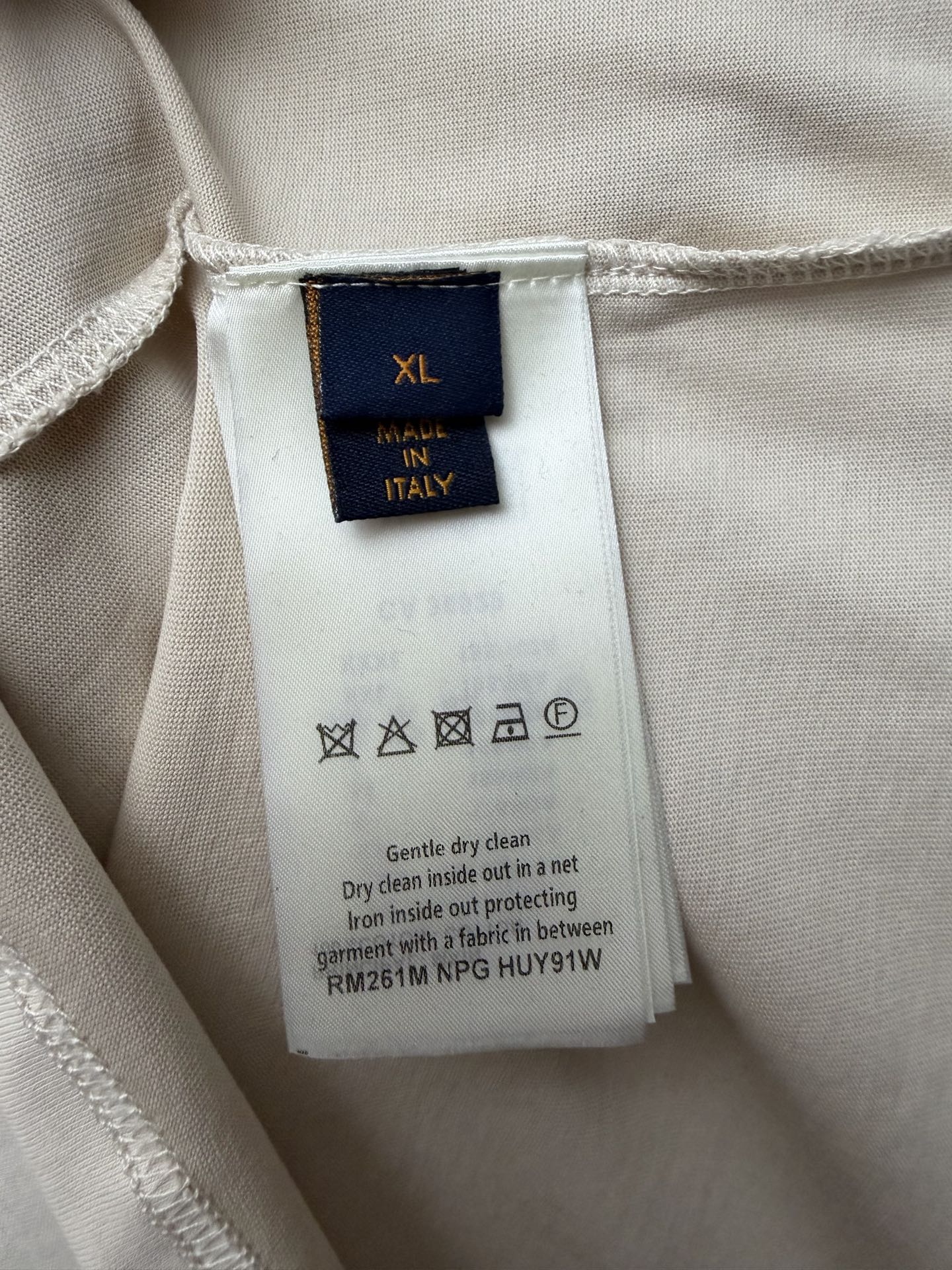 Louis Vuitton T-shirt size XL care label with icons and cleaning instructions.