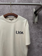 Louis Vuitton T-shirt in light cream with L.V.M. logo and crew neckline close-up.