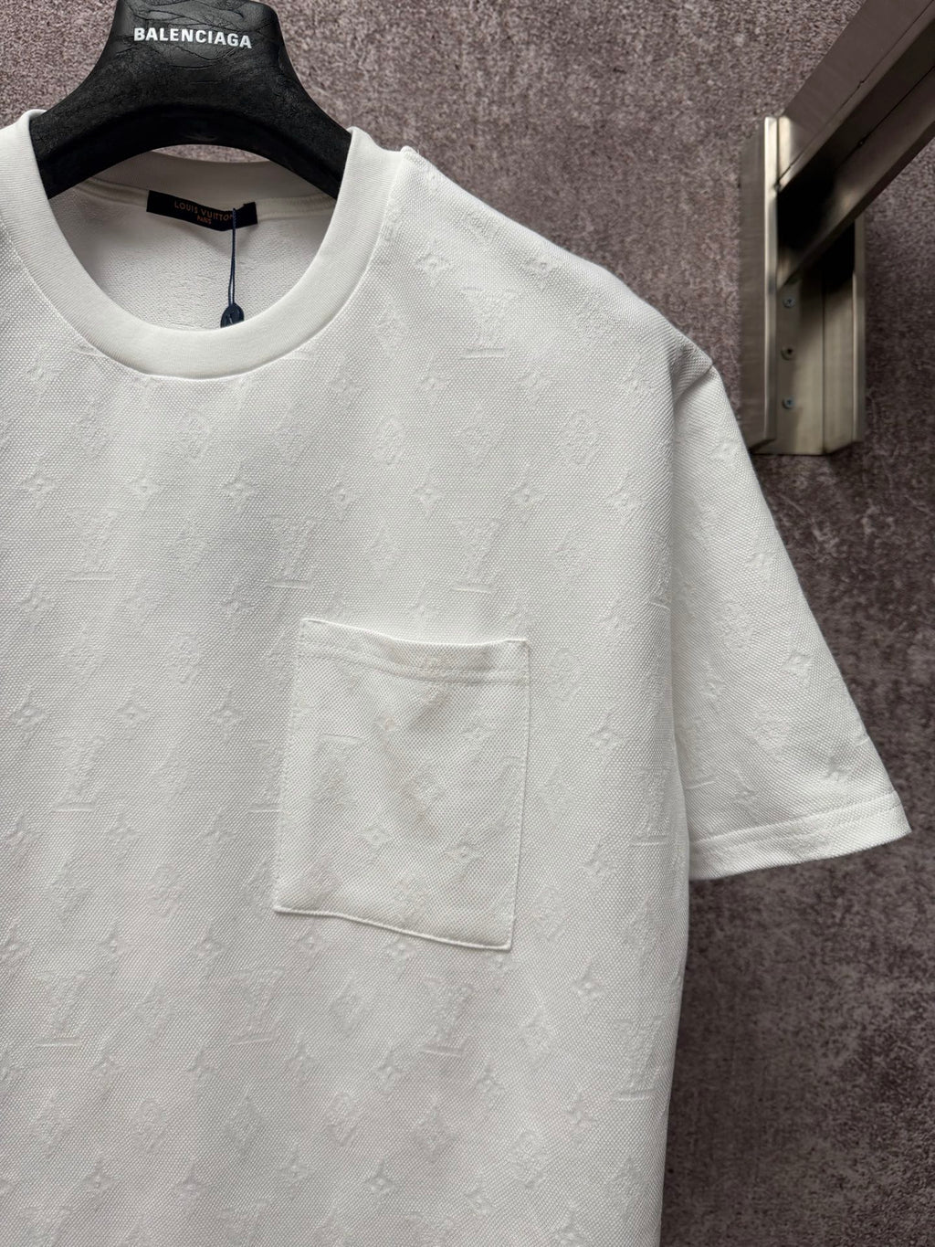 White short-sleeve T-shirt with crew neck and front chest pocket, close-up