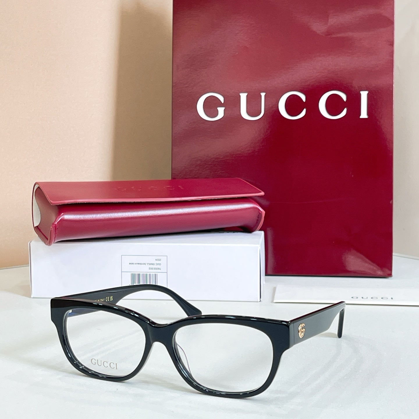 Black rectangular glasses with red and green striped temple details, with case and box.