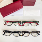 Two pairs of glasses with red and green stripe temples, shown with red case and boxes.