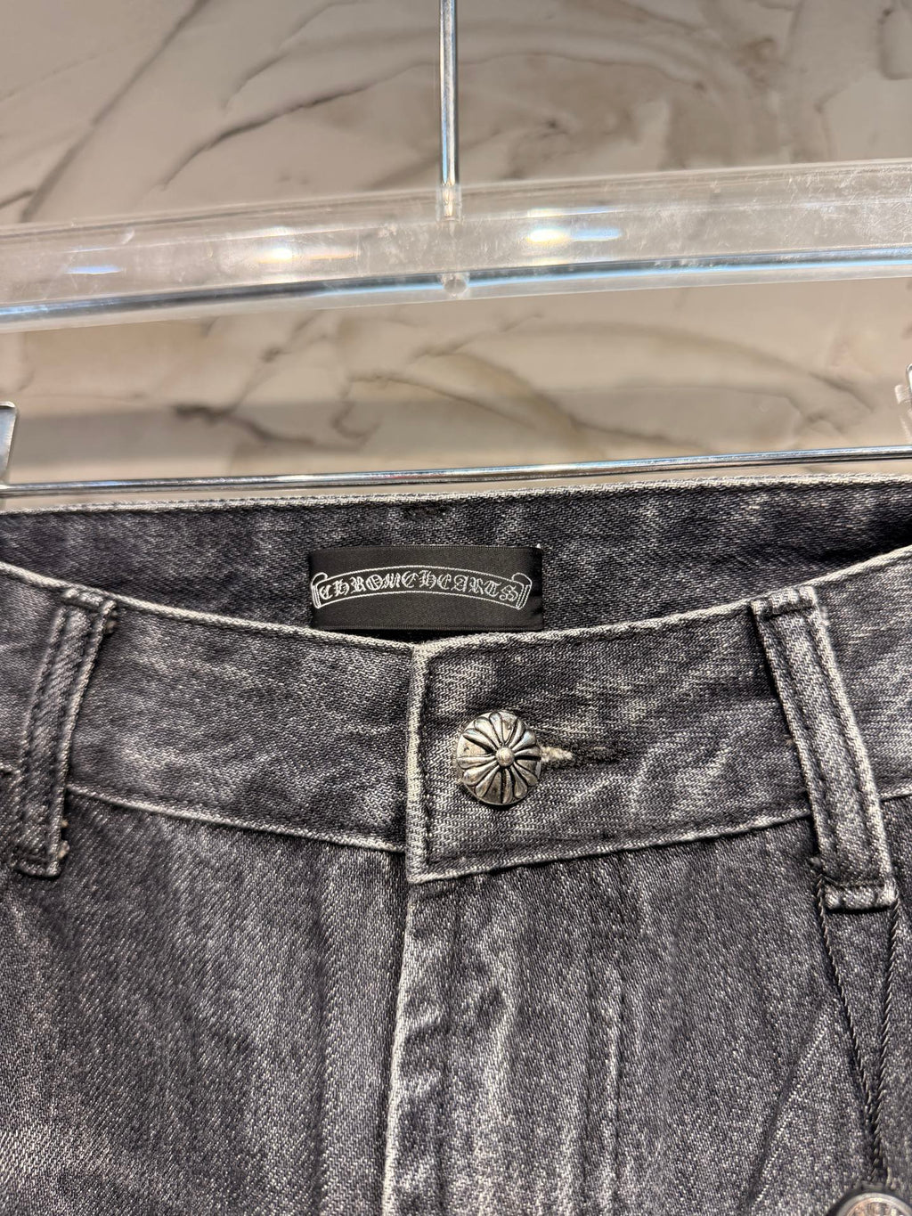 Denim pants waistband with logo patch and front button detail