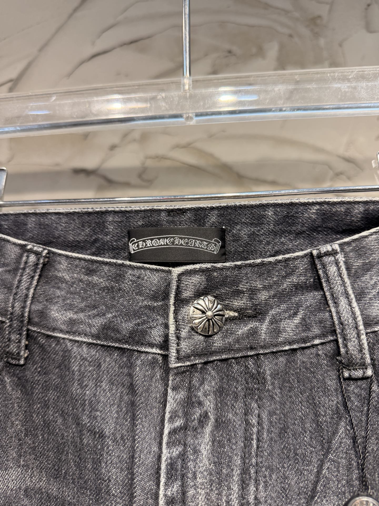 Denim pants waistband with logo patch and front button detail