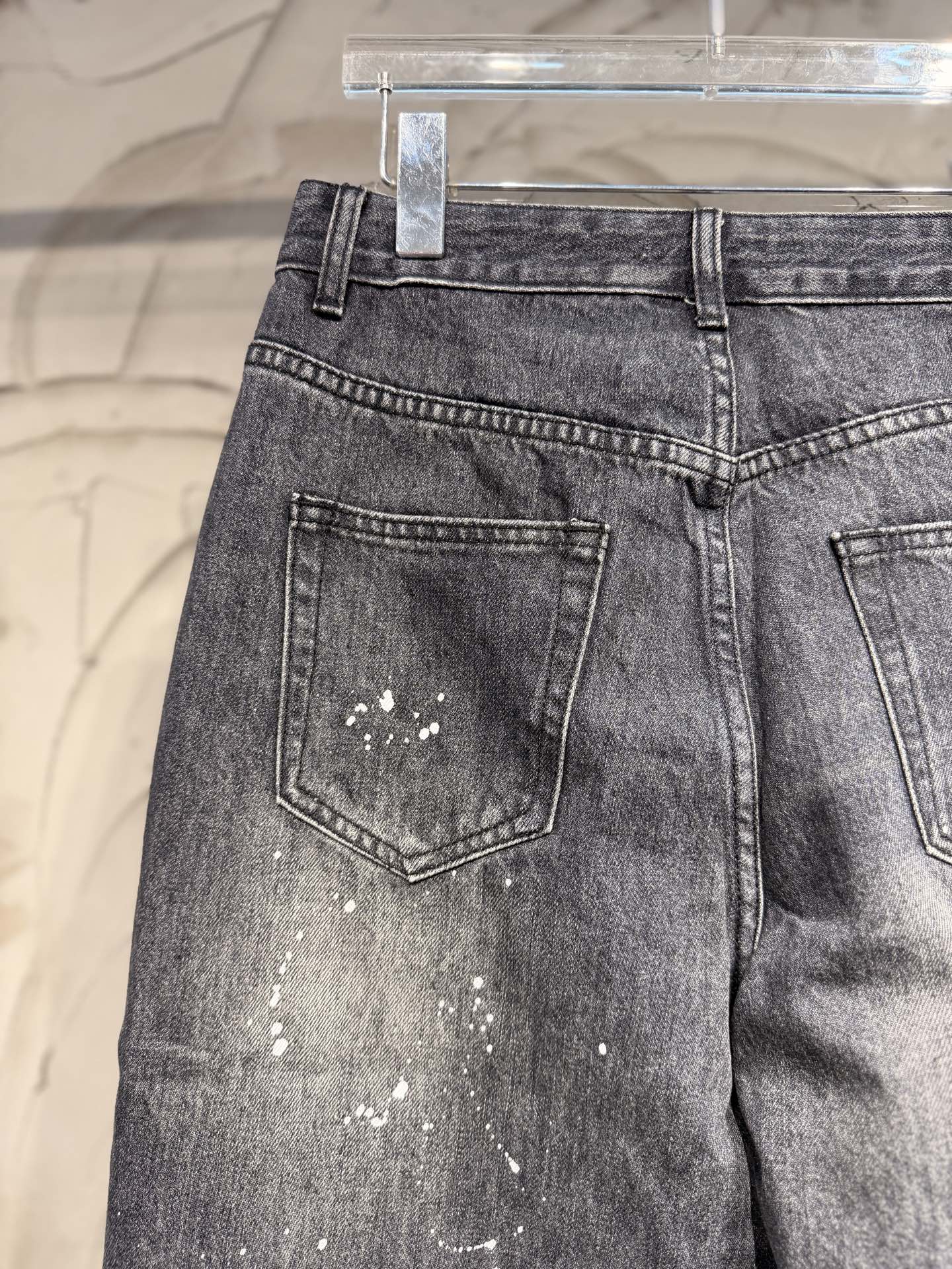 Dark gray denim pants with back pockets and scattered white speckles