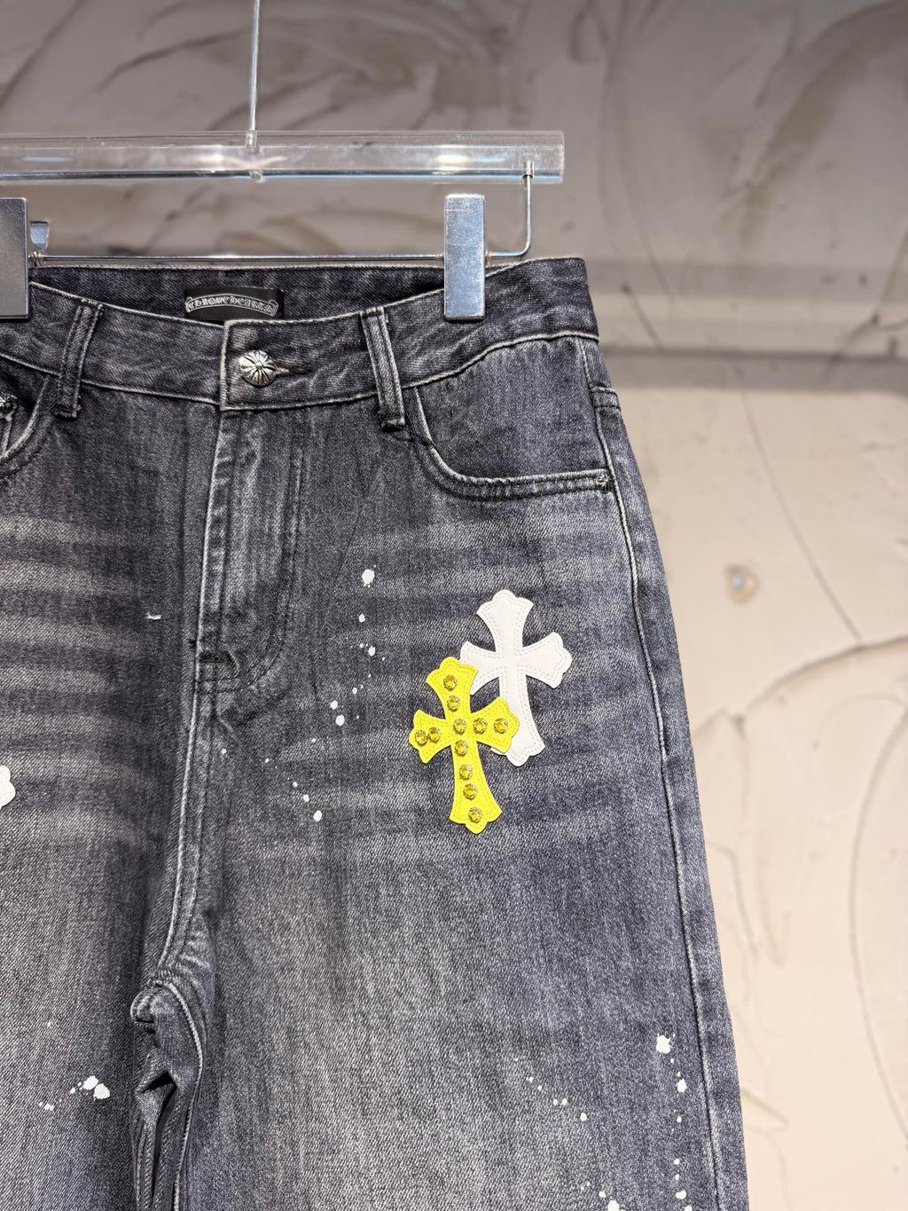 Dark gray denim pants with side view and large white cross graphic
