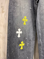 Dark gray denim pants leg with white and yellow small cross patches