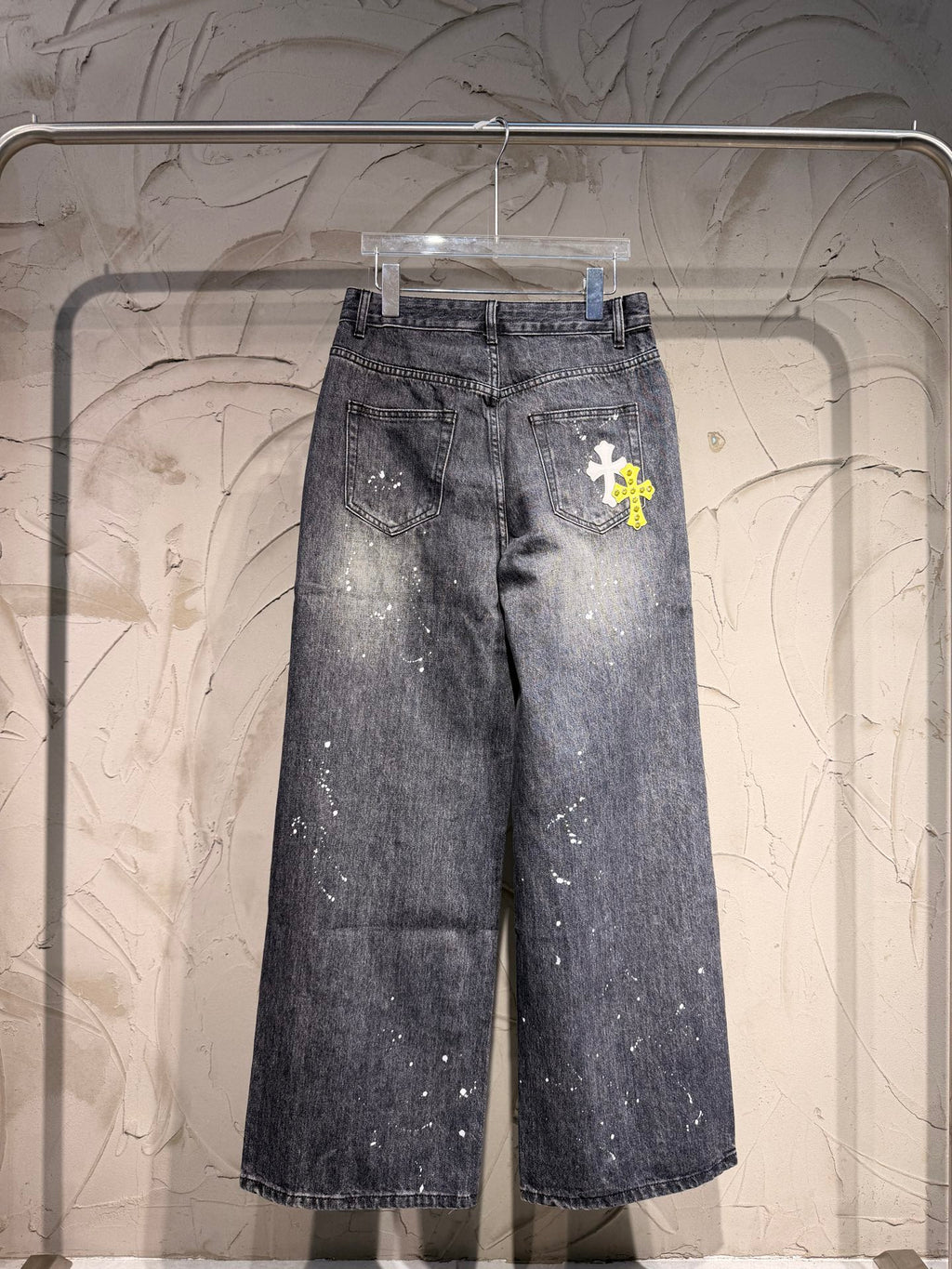 Dark denim pants with scattered white paint speckles, wide leg
