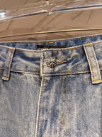 Light blue denim pants with metal-button closure and small cross emblem on waistband