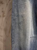 Light blue denim pants with textured studded detailing on the front leg