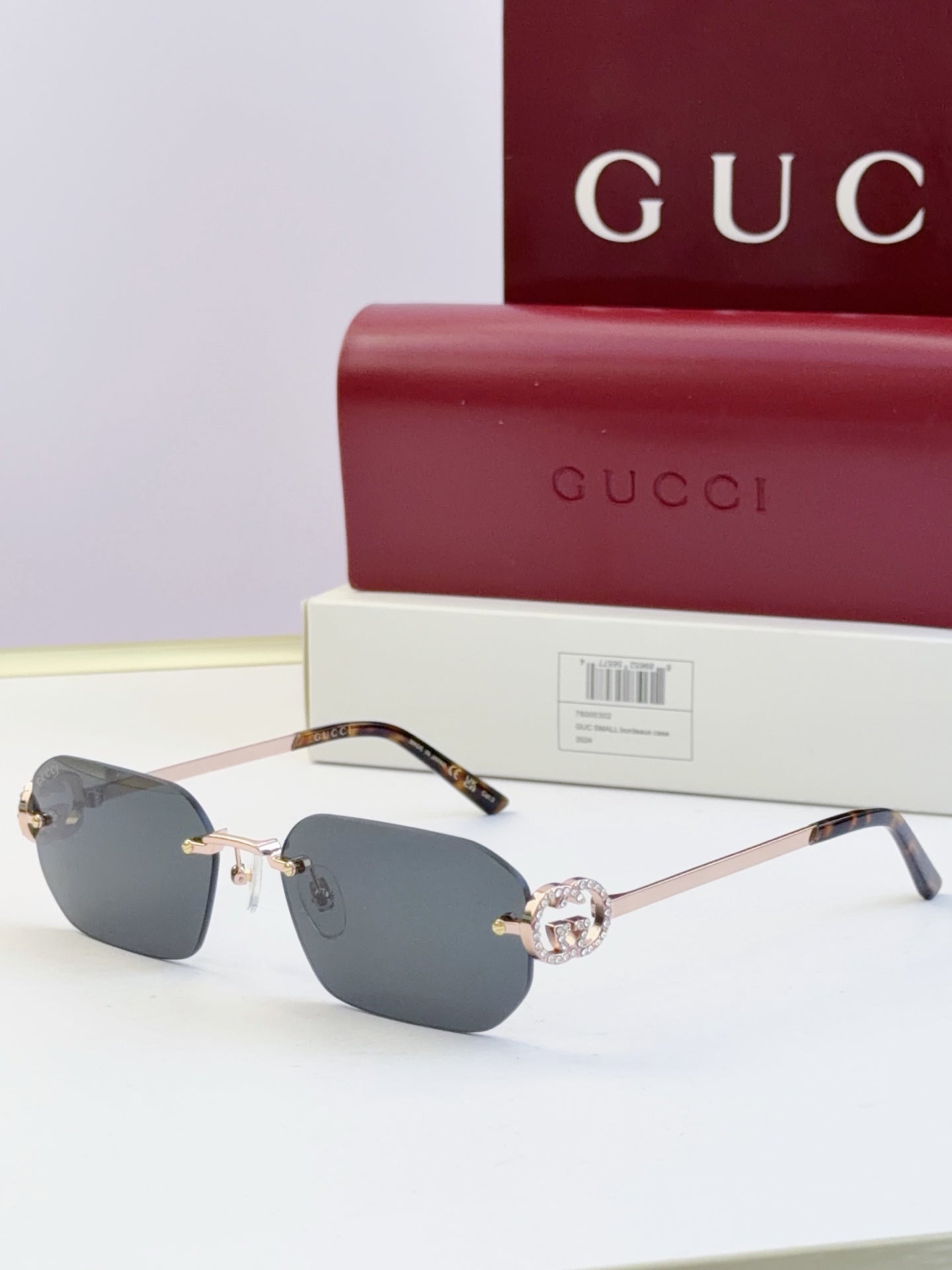 Gucci sunglasses with dark blue lenses, gold frame, tortoise temples, round logo stud