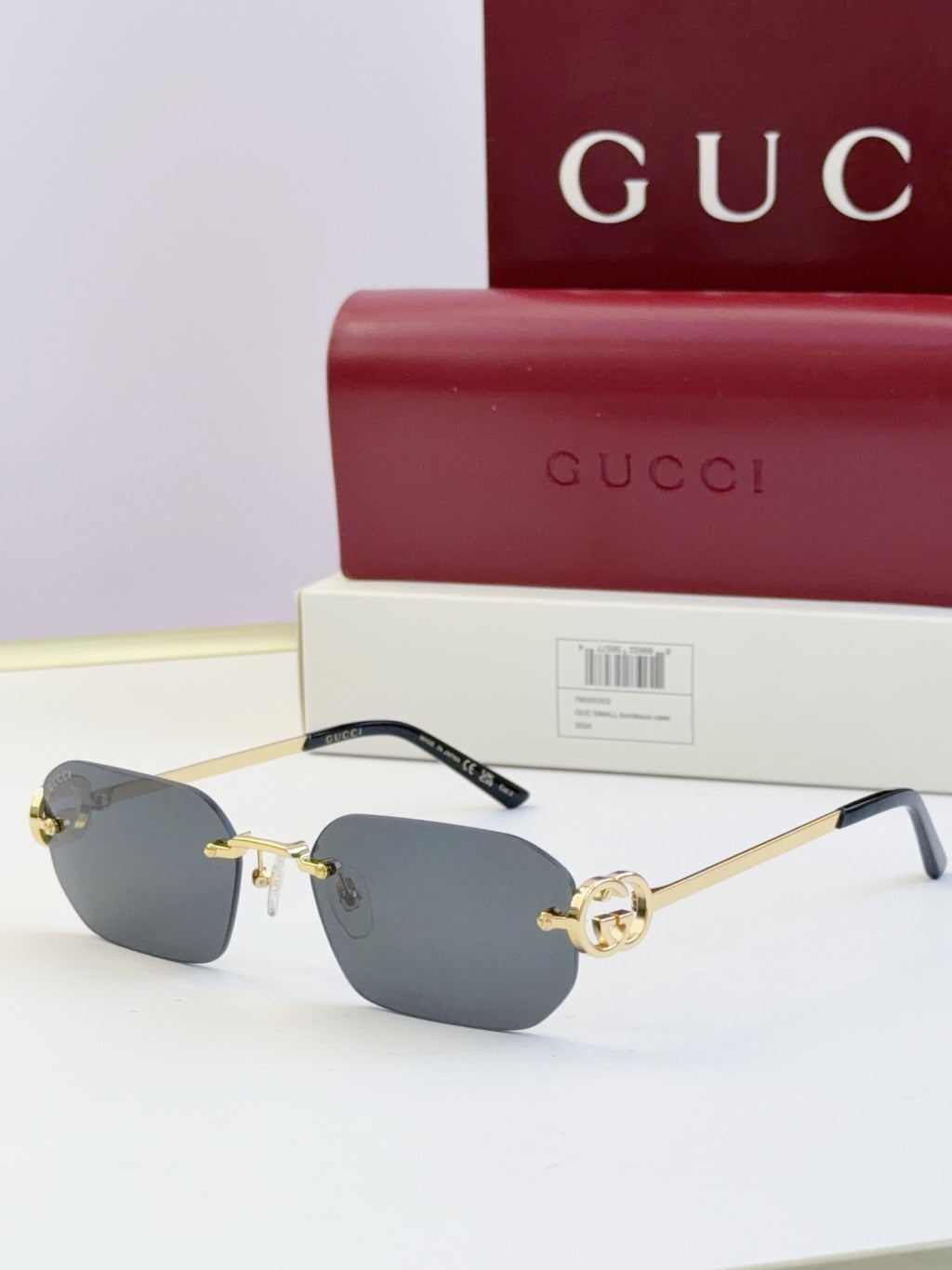 Gucci sunglasses with dark blue lenses, gold frame, tortoise temples, round logo stud