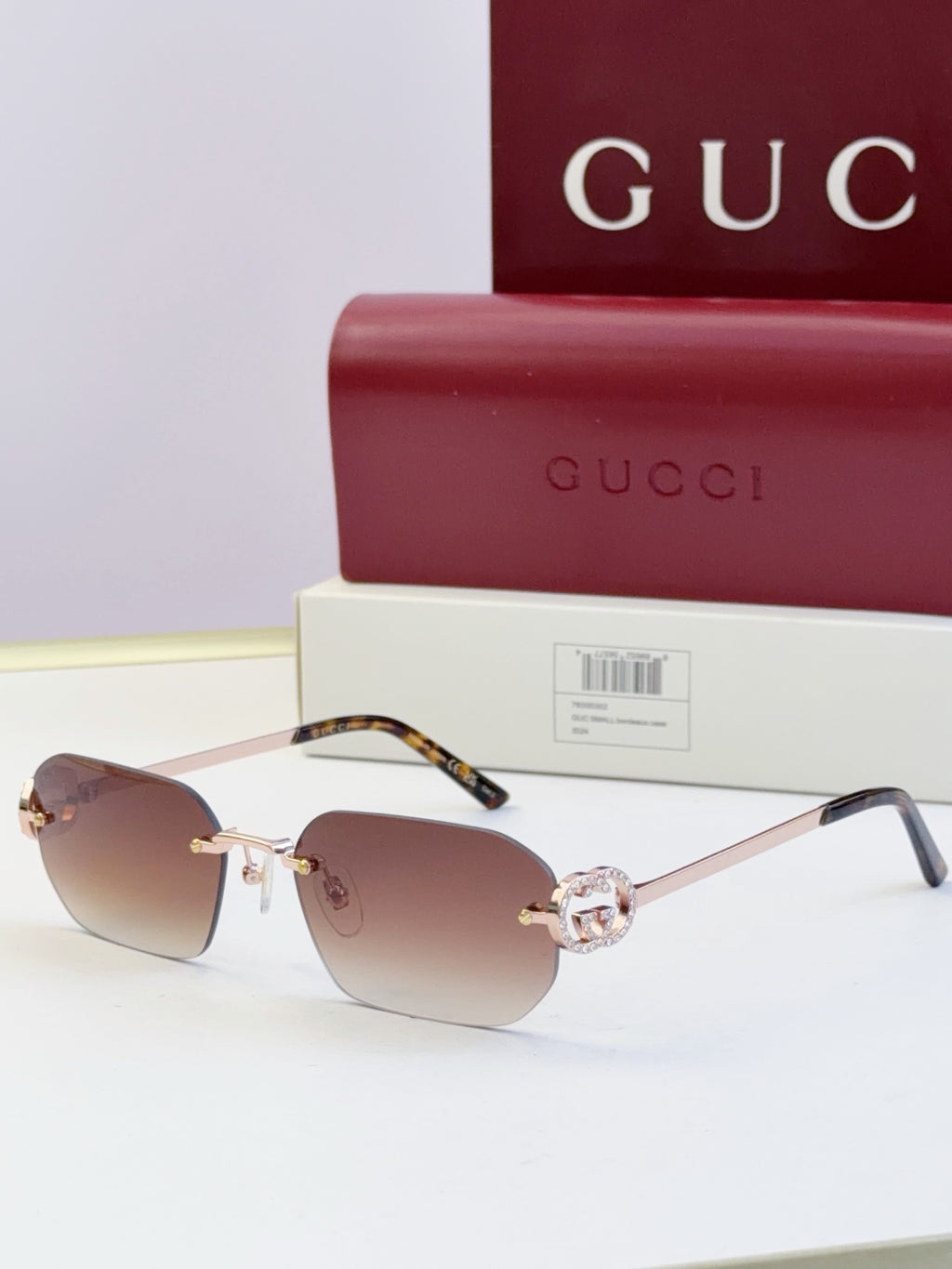 Gucci sunglasses with brown lenses, gold frame, tortoise temples, round logo stud