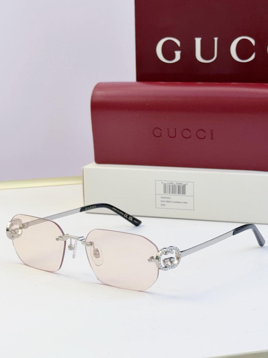 Gucci sunglasses with light lenses, clear frame, gold-toned bridge with round stud