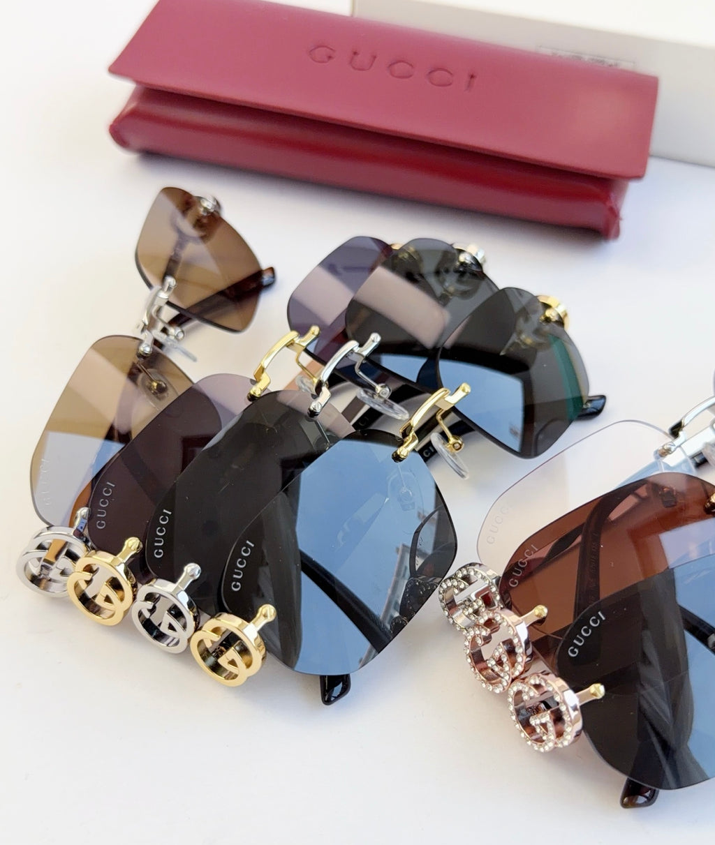 Assorted Gucci sunglasses with gold-tone frames and ornate logo charms, mixed lens colors