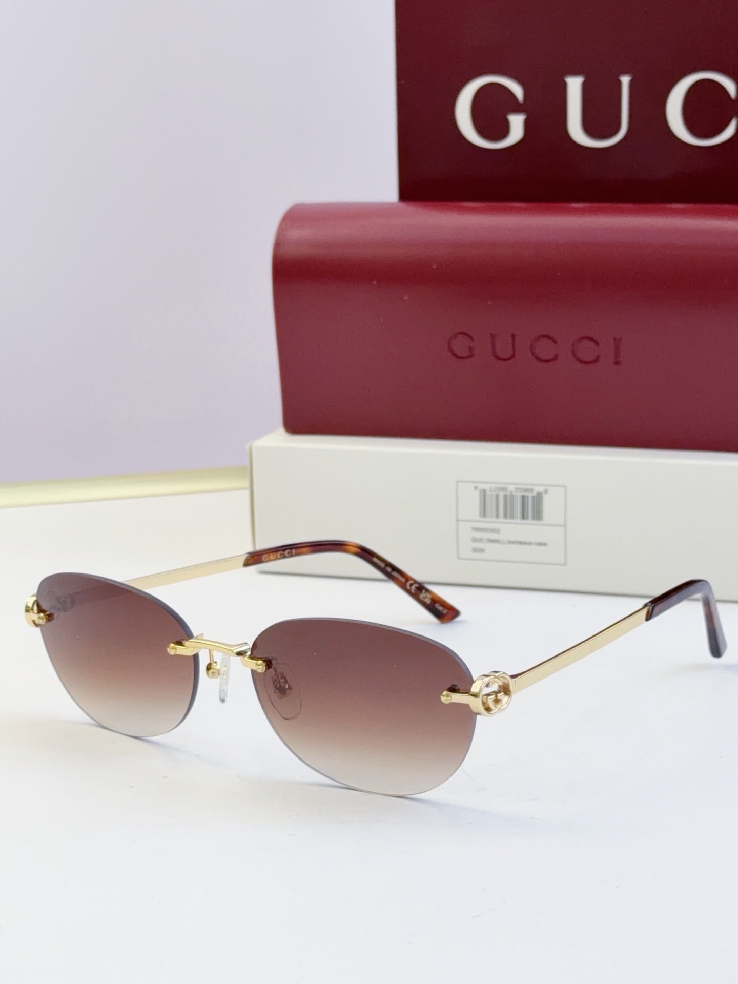 Gucci round sunglasses with gold-tone metal frame, tortoise temples, and dark lenses