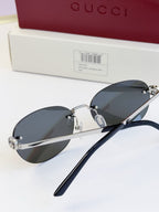 Gucci round sunglasses with gold-tone frame, black temples, and dark blue lenses
