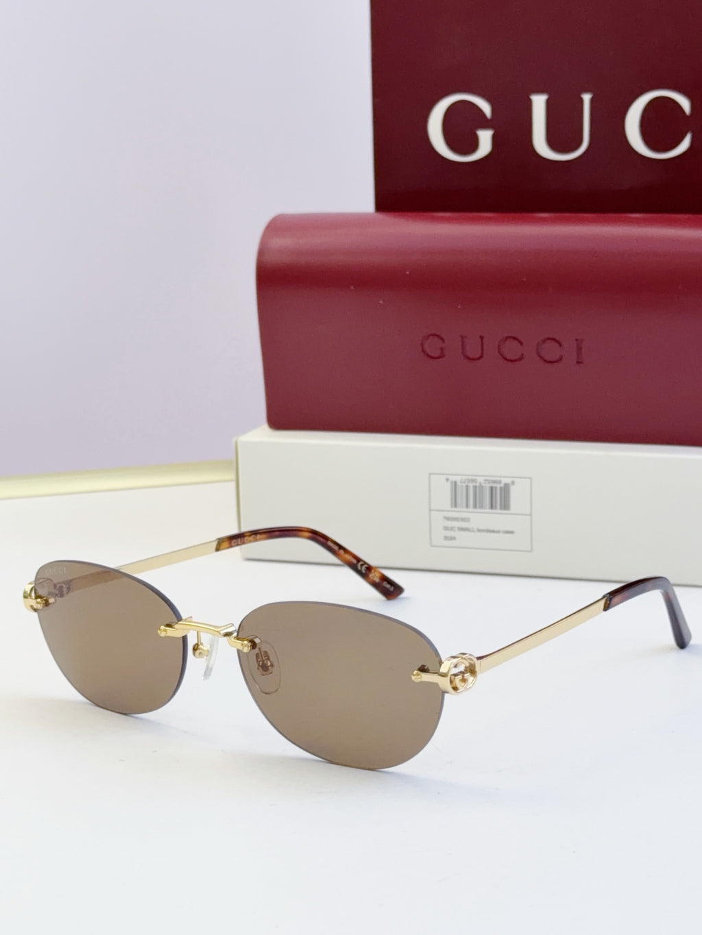 Gucci round sunglasses with gold-tone metal frame, tortoise temples, and neutral lenses