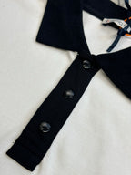 Close-up of polo placket with black buttons and white fabric