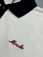 Close-up of polo chest with red script logo on white fabric