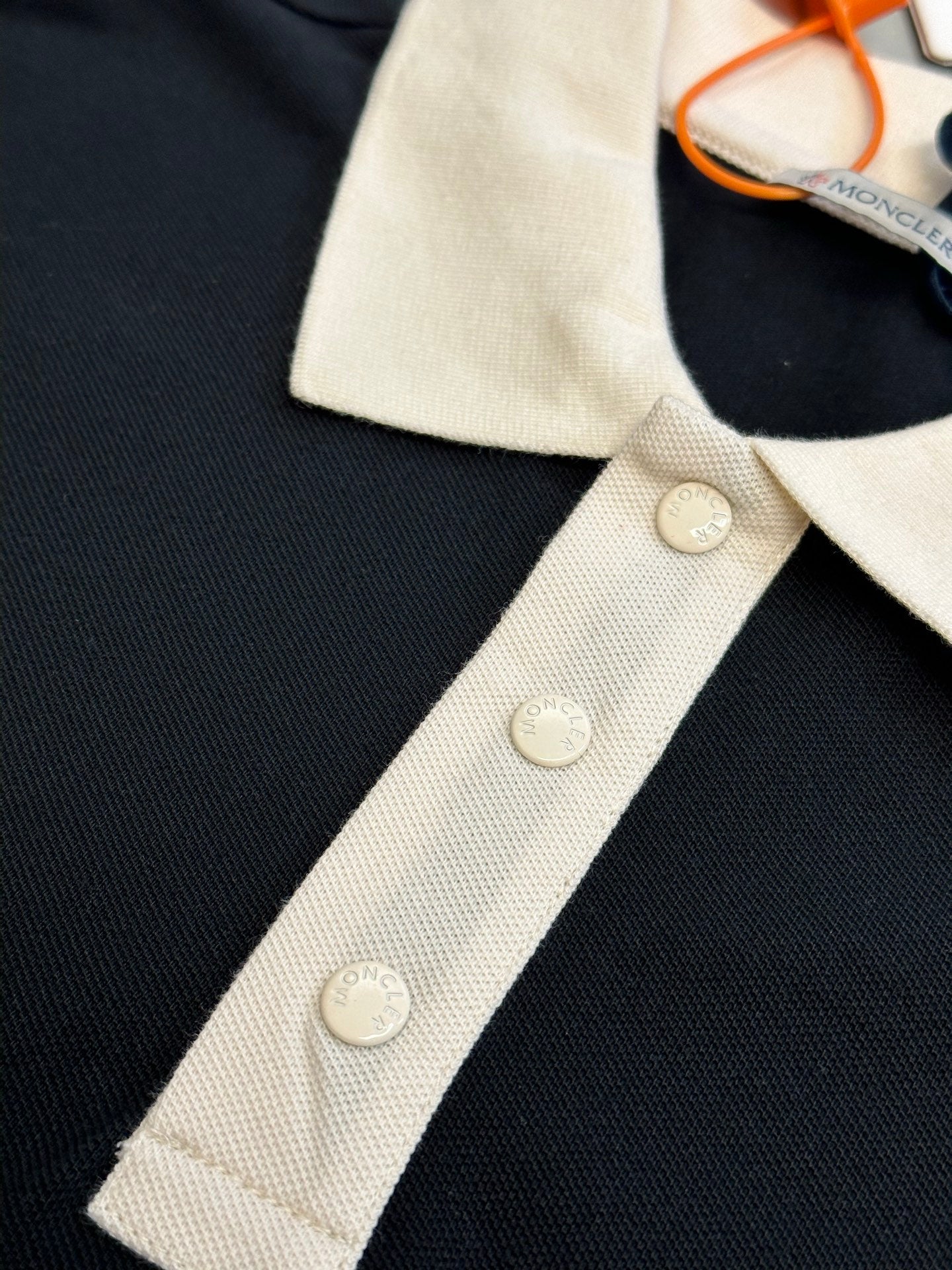 Moncler polo shirt placket detail with cream buttons on dark navy fabric