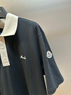 Moncler navy polo shirt side view with cream collar and circular sleeve logo patch