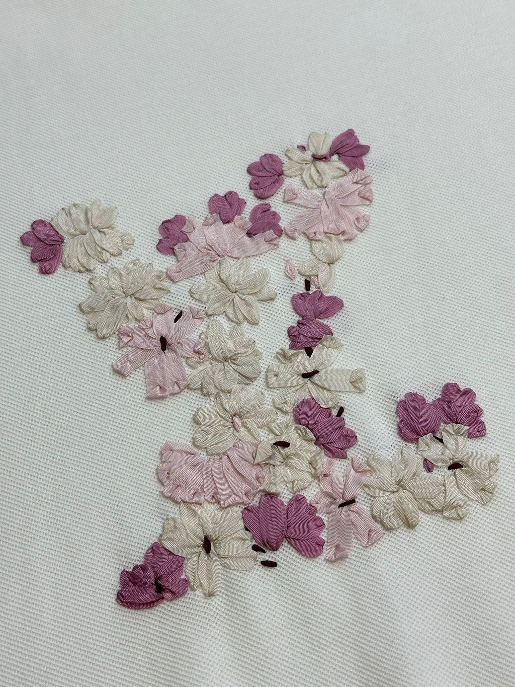 Close-up of multicolor floral appliqué on white textured T-shirt fabric