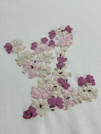 Close-up of multicolor floral appliqué on white textured T-shirt fabric