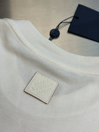 White T-shirt with embossed leather brand patch and navy hang tag