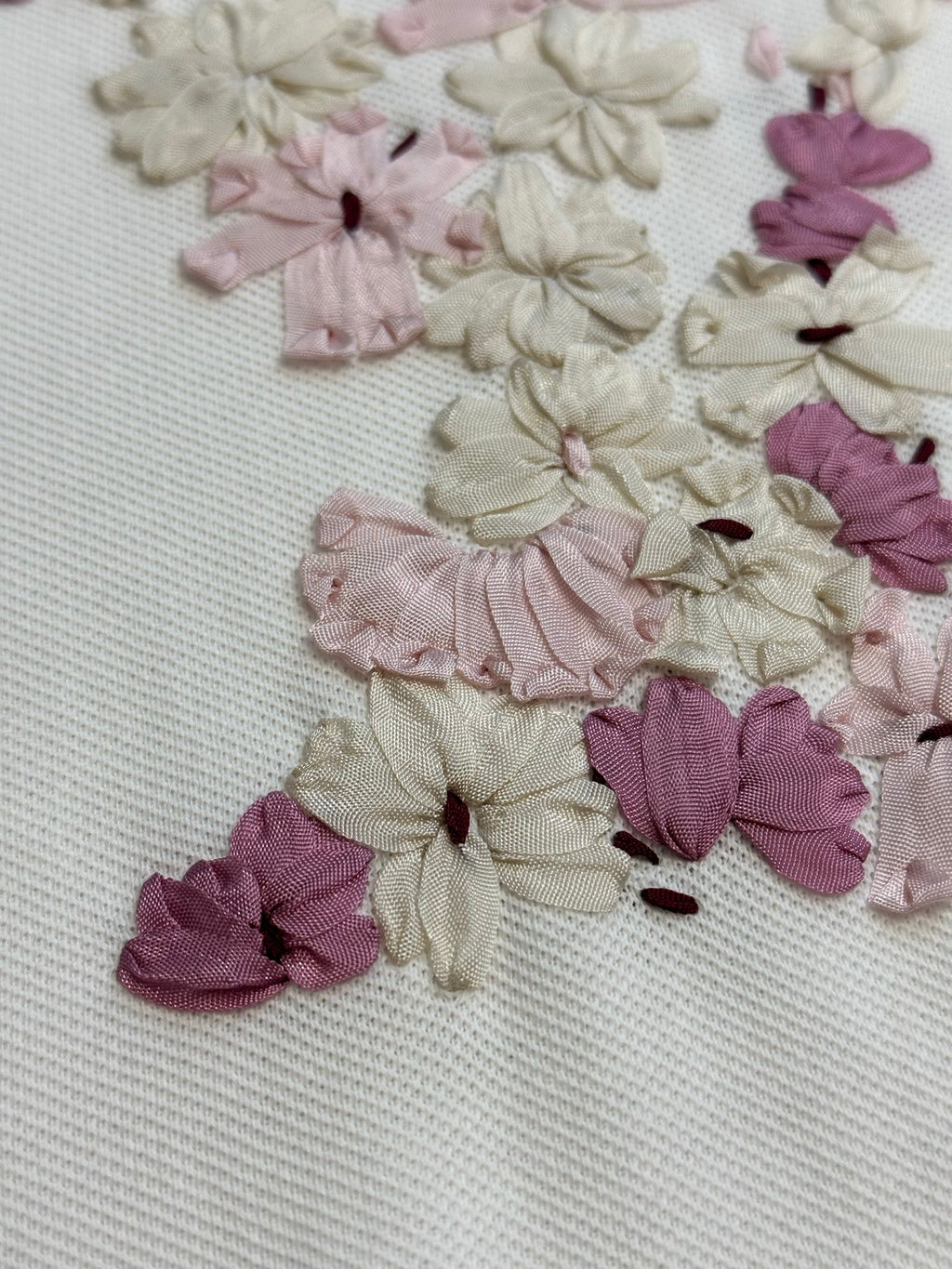 Close-up of floral appliqué detail on white T-shirt fabric