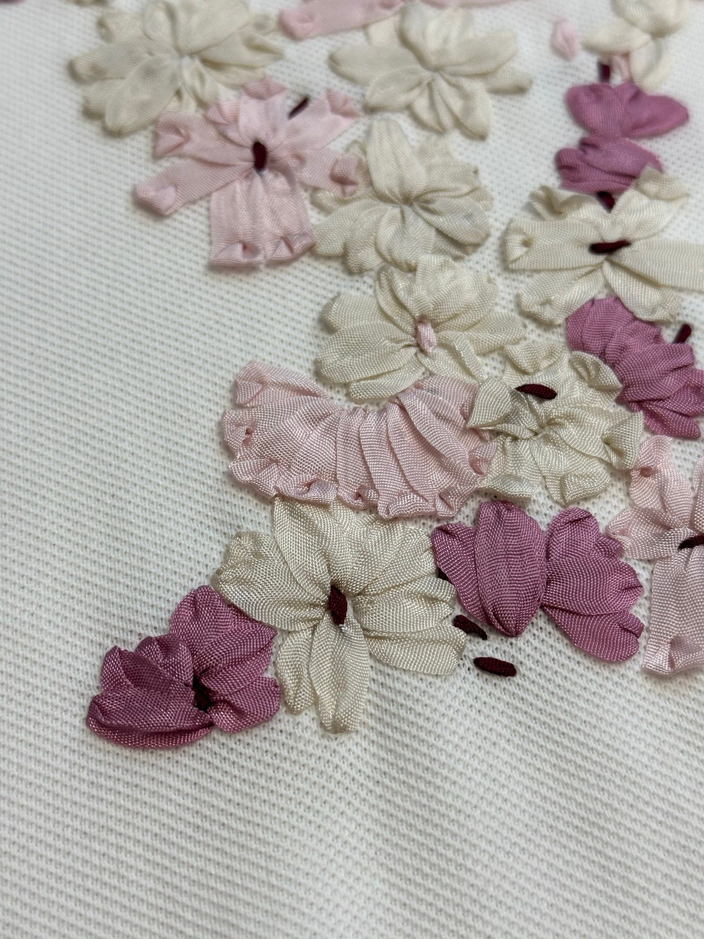 Close-up of floral appliqué detail on white T-shirt fabric