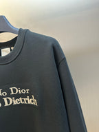 Black sweatshirt sleeve with 'No Dior No Dietrich' text print