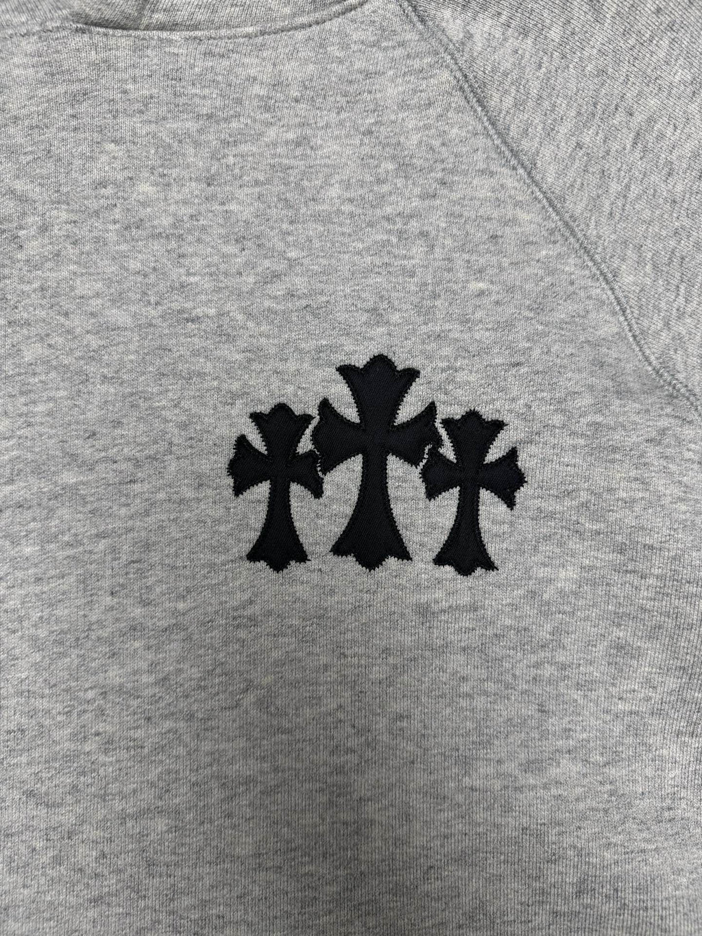 Light gray hoodie with black star-like logo on the chest
