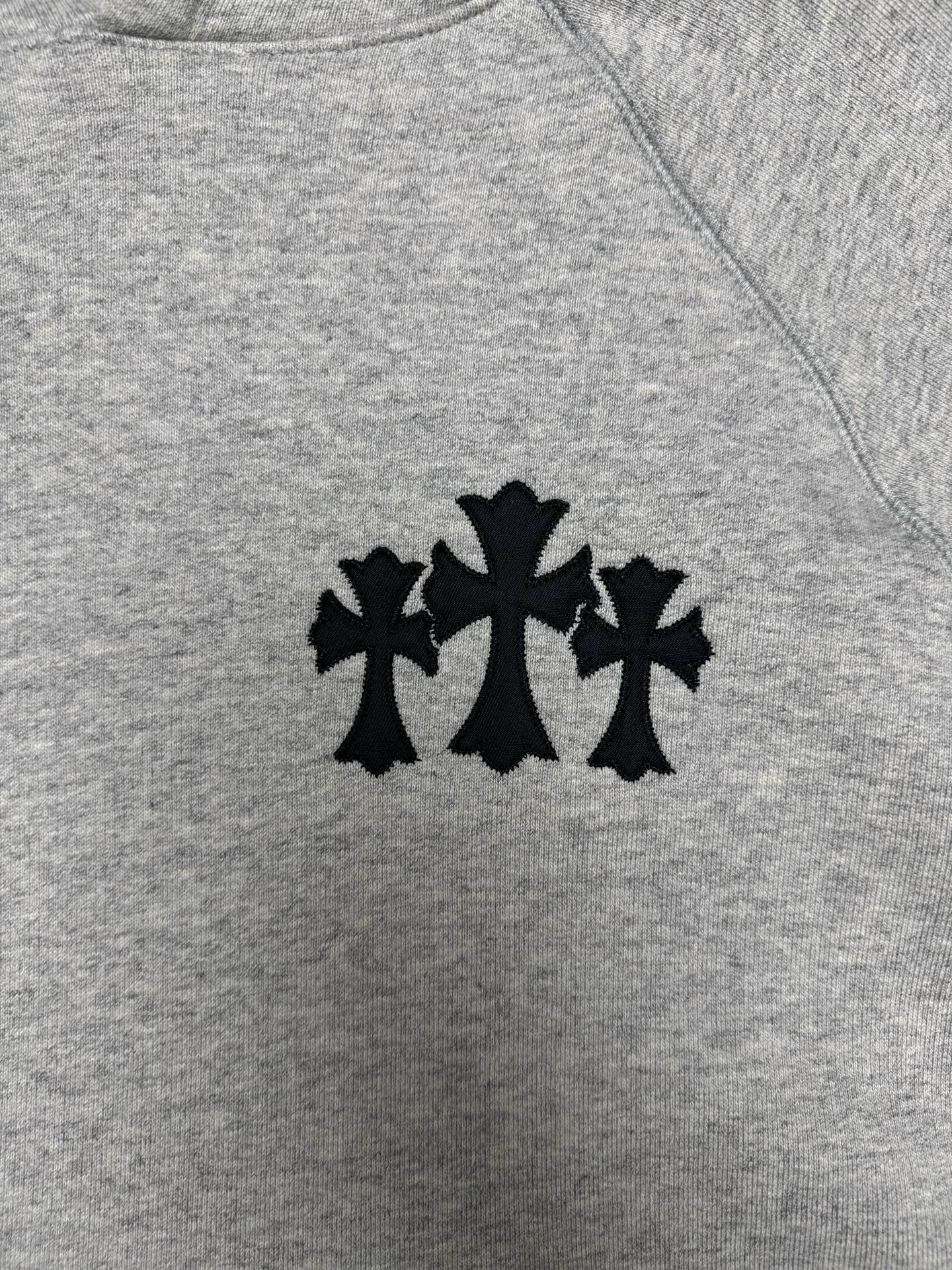 Light gray hoodie with black star-like logo on the chest