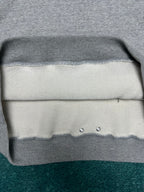 Light gray hoodie hem with ribbed trim and two metal eyelets