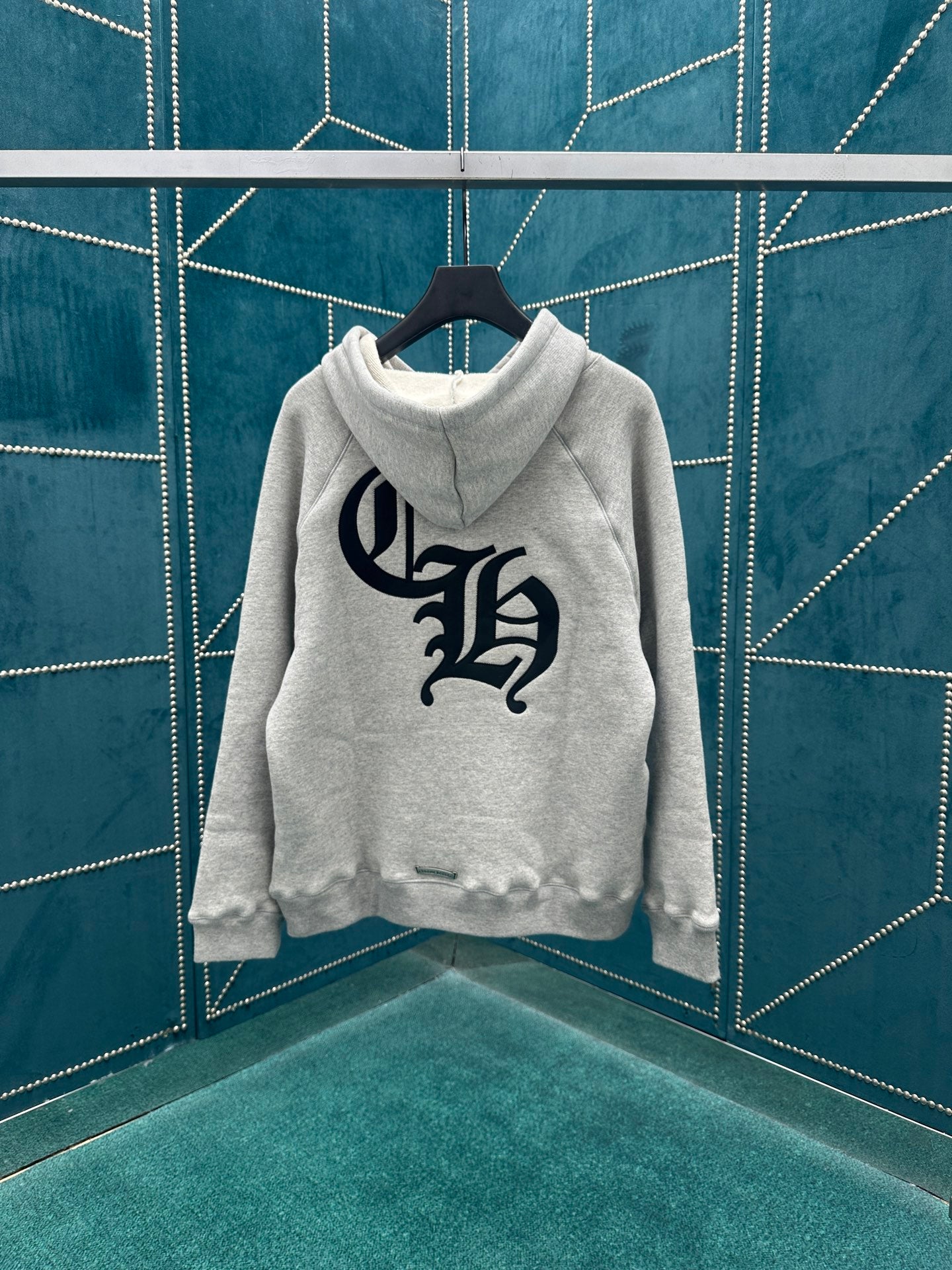 Light gray pullover hoodie with large dark logo on chest