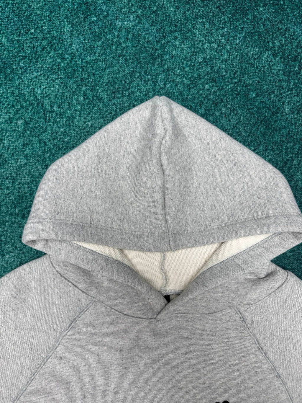 Light gray hoodie with hood and folded neckline seam detail