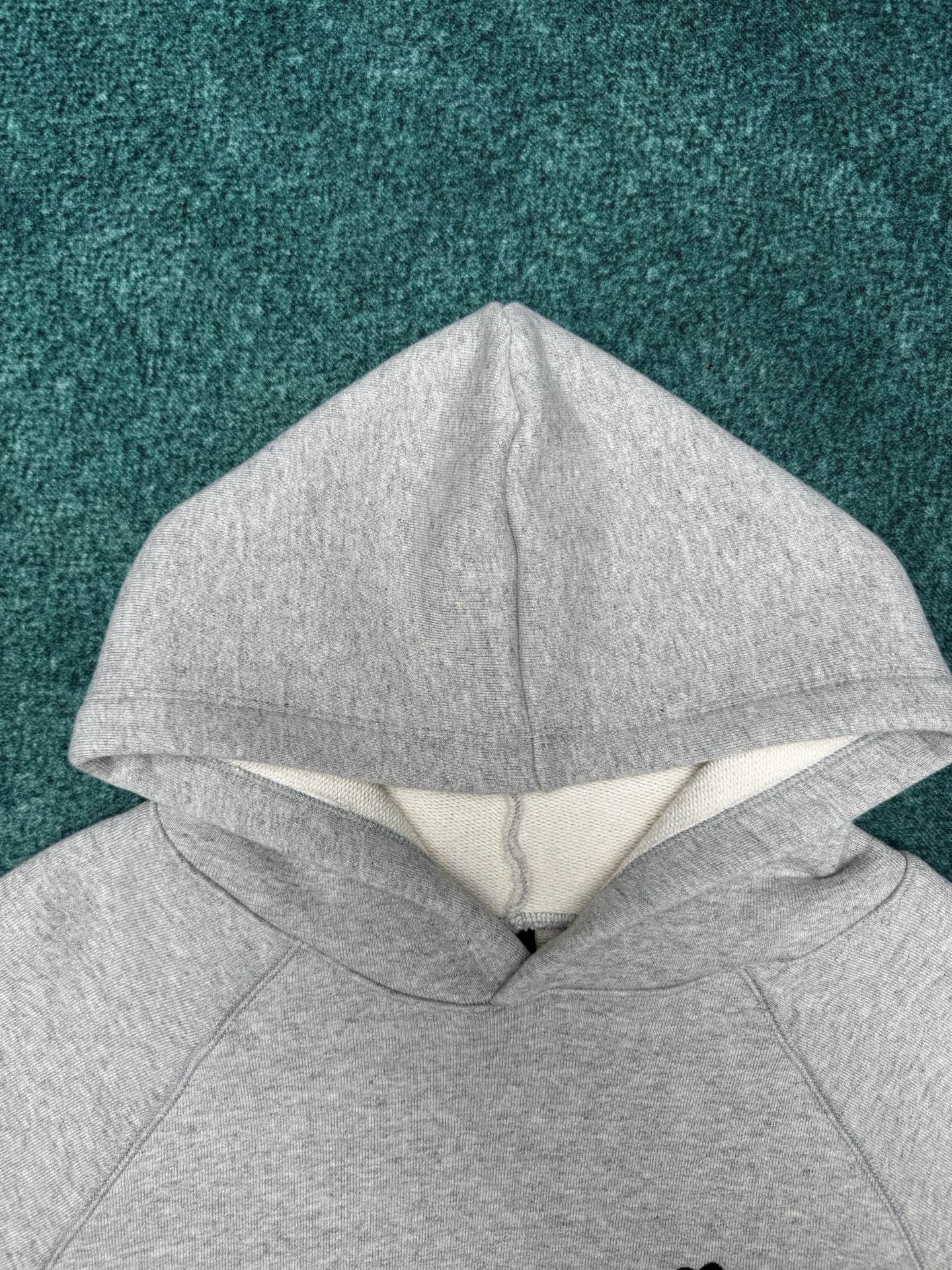 Light gray hoodie with hood and folded neckline seam detail